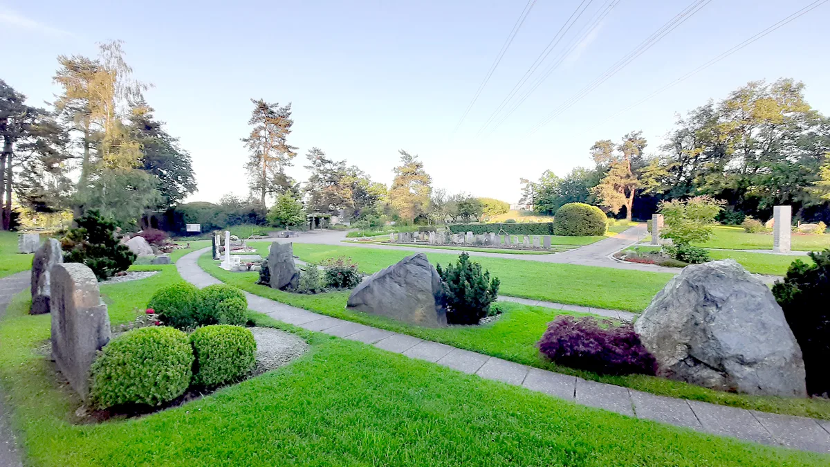 Friedhof mit Grabsteinen und Wegen.